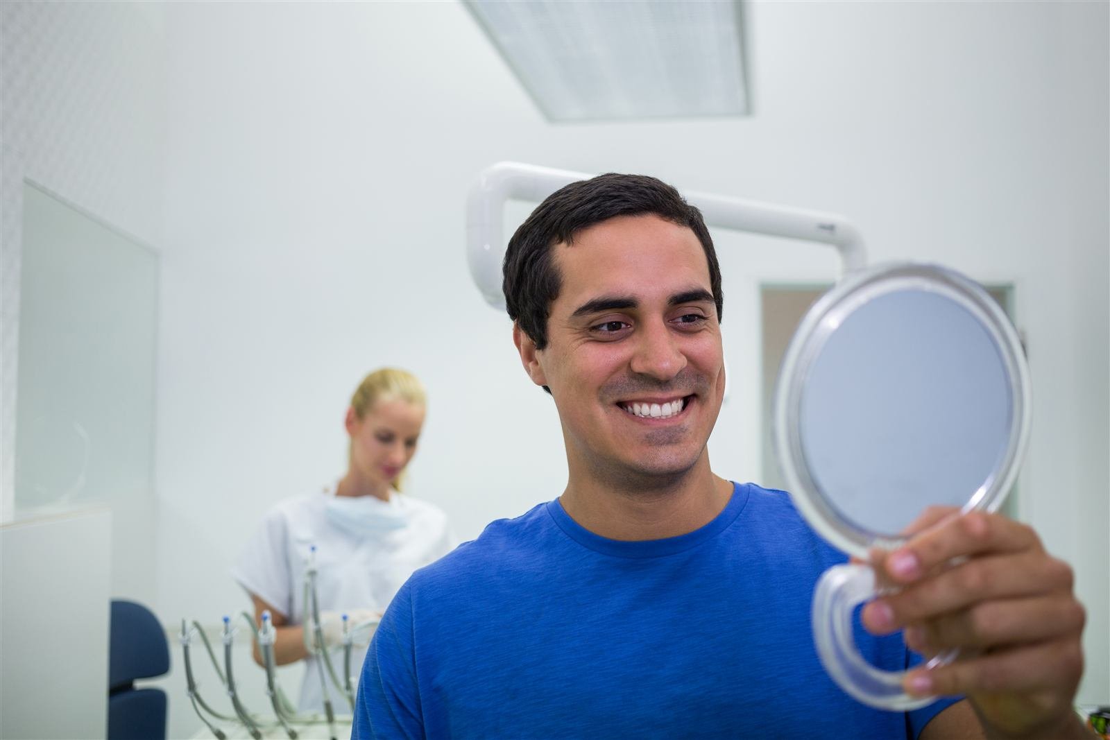 Paciente revisando su sonrisa en un espejo